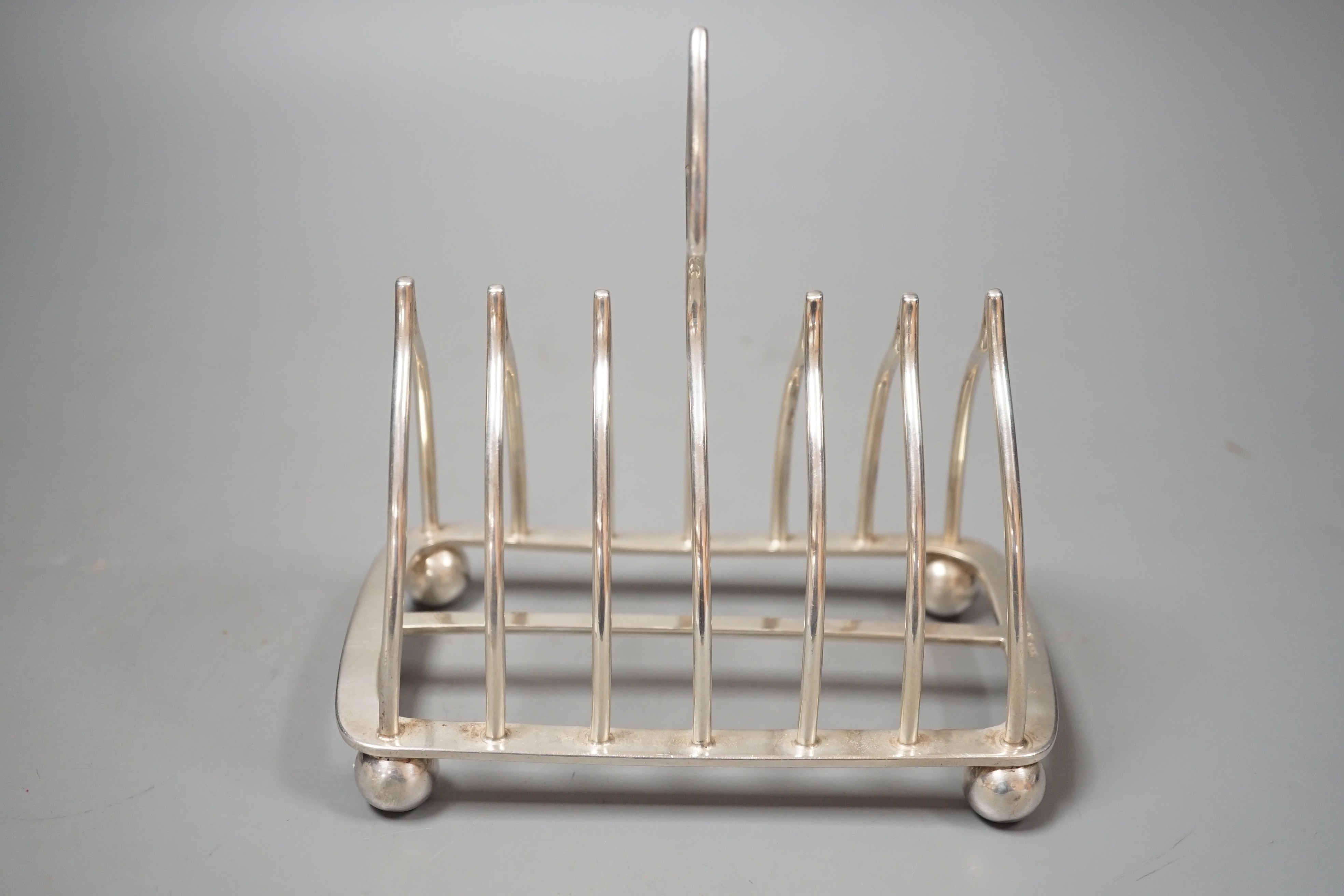 An Edwardian silver eight bar toast rack, on ball feet, by Elkington & Co, Birmingham, 1902, length 15.4cm, 10oz.
